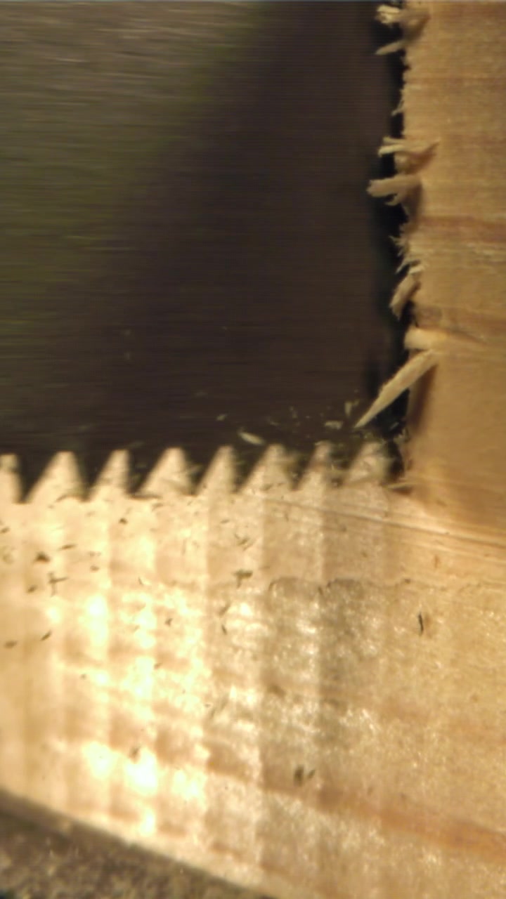 Close-up of a saw blade cutting into wood