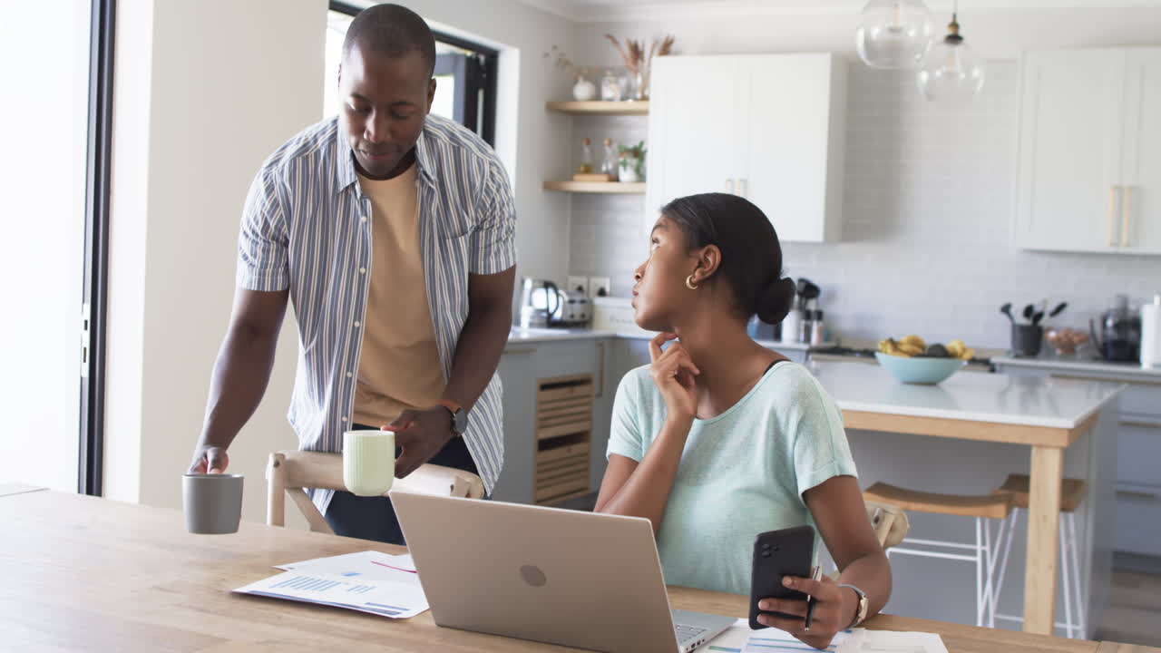 African American couple is focused on their laptop at home, paying bills