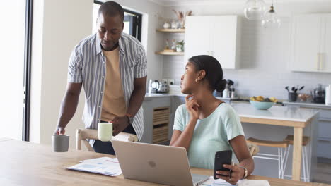 La-Pareja-Afroamericana-Se-Concentra-En-Su-Computadora-Portátil-En-Casa,-Pagando-Facturas