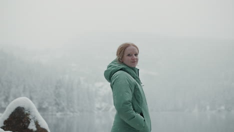 woman in winter landscape by a snow-covered lake