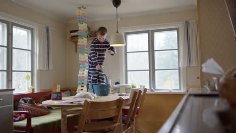 boy dejected after tall stacked wooden block tower on kitchen table collapses