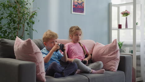 toddler and preschooler play video game using gaming console