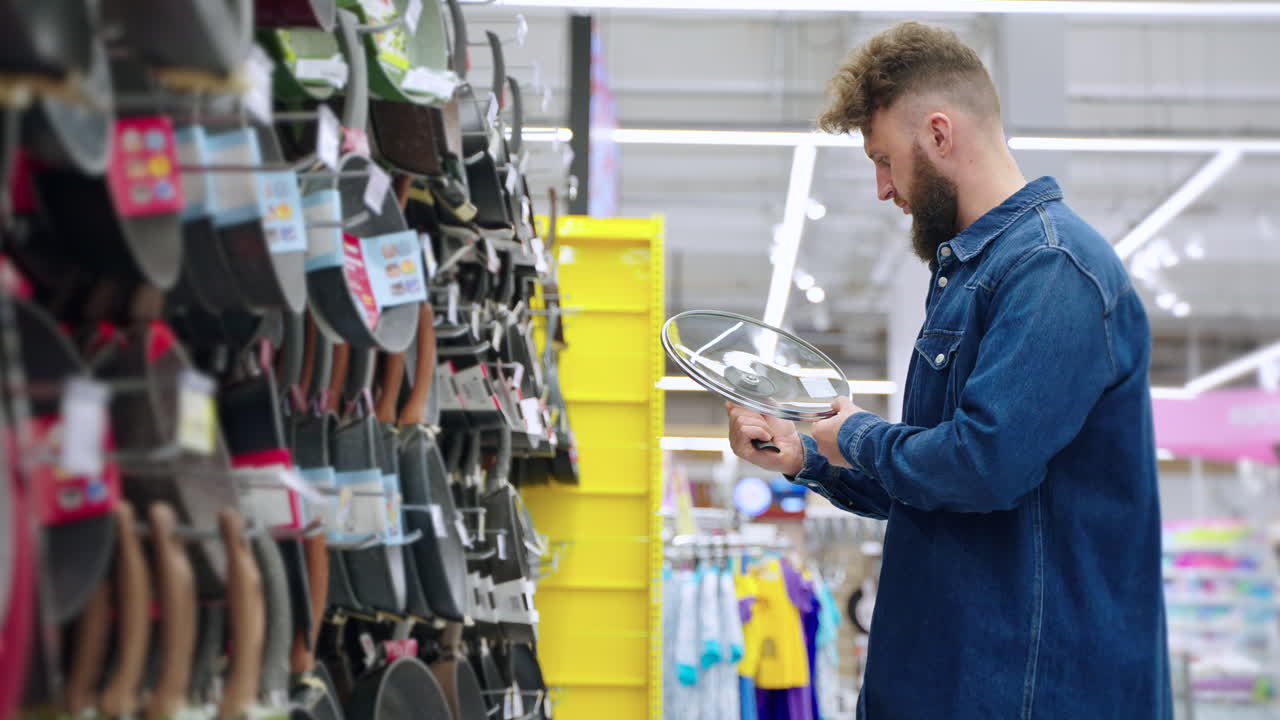 Uomo che fa acquisti di articoli per la cucina in un supermercato