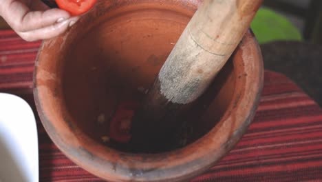 Serie-De-Cocina-Som-Tam:-Cámara-Lenta,-Vendedor-De-Comida-Callejera-Cortando-Tomate-Y-Poniéndolo-En-Mortero-Para-Hacer-Som-Tam-O-Ensalada-De-Papaya-Verde-Picante-Tailandesa,-Uno-De-Los-Platos-Más-Populares-De-Tailandia