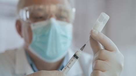 close up shot of unrecognizable nurse or doctor in gloves filling syringe from ampule with covid-19 vaccine. nurse filling injection syringe from vial. high quality 4k footage