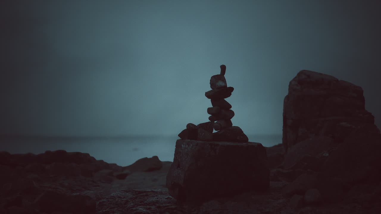 Stacked stones at dusk near ocean creating a tranquil ambiance