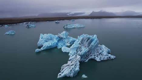 orbit around massive icebergs in iceland on a gloomy overcast day