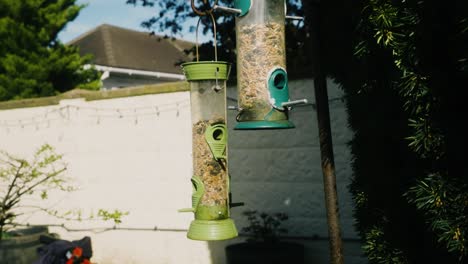 Toma-En-Cámara-Lenta-De-Comederos-Para-Pájaros-Balanceándose-En-El-Viento