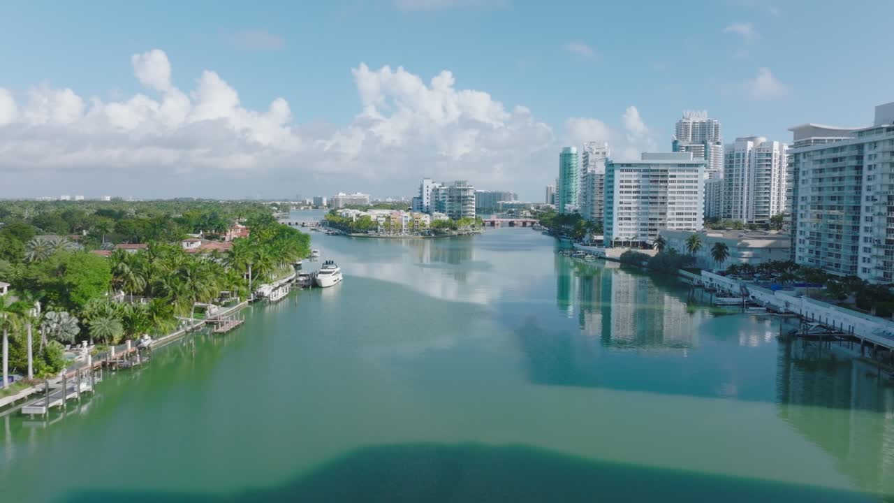 도시에서  ⁇ 은 날, 포워드는 현대적인 다층 주거 건물로 둘러싸인 물 표면 위로 날아갑니다. 마이애미, 미국