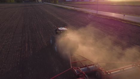 Wunderschöne-Drohnenaufnahme-Eines-Traktors-Bei-Sonnenuntergang