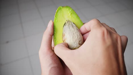 신선 한 아보카도 반 조각 에 씨 을 넣는 사람