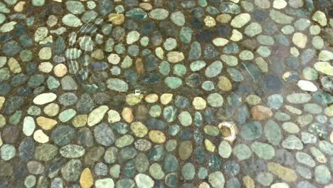 textura del agua en la piscina con rocas de guijarros