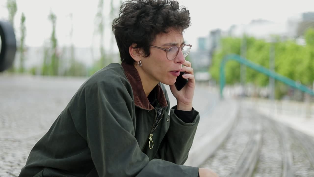 mujer infeliz hablando por teléfono inteligente en la calle
