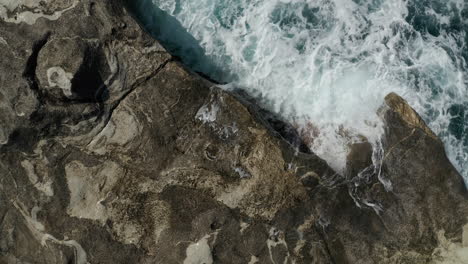 Luftaufnahme-Von-Oben-Nach-Unten-Aus-Der-Vogelperspektive-Von-Großen-Wellen,-Die-Wasser-Auf-Felsen-Stürzen-Und-Spritzen