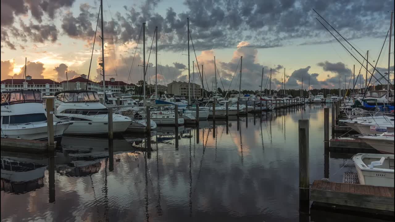 lapso de tiempo del amanecer en un puerto deportivo con barcos y nubes.