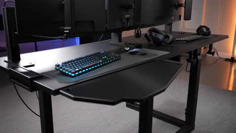 modern gaming desk setup with rgb keyboard and multiple monitors
