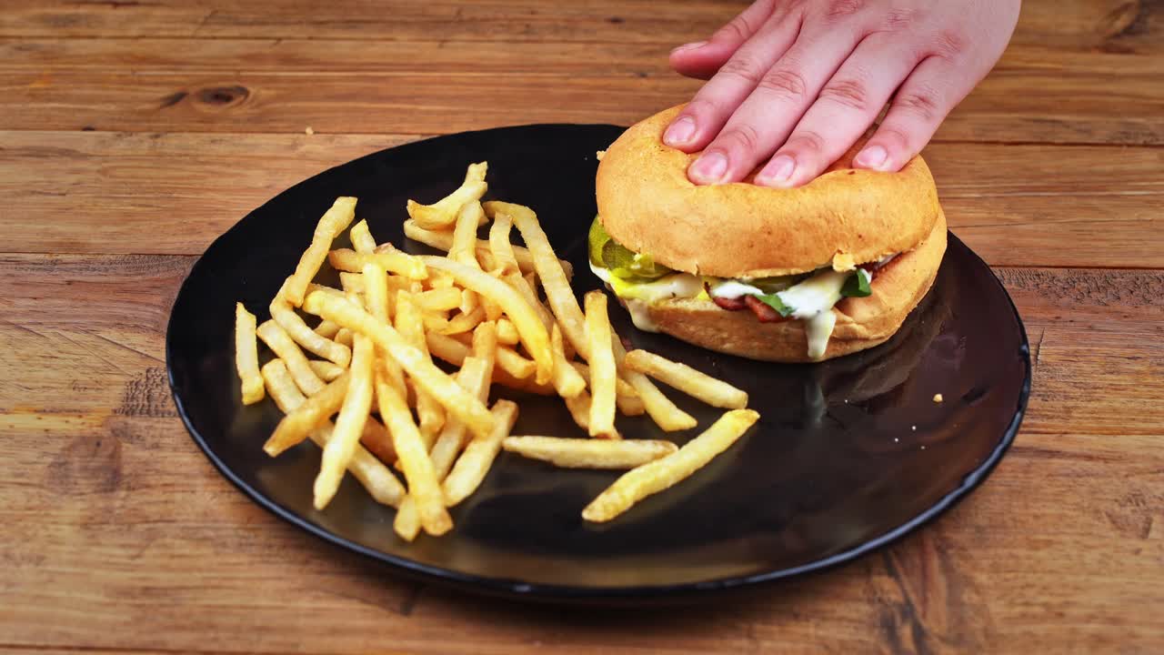 primer plano detallado de una hamburguesa de hongos acompañada de papas fritas que está ligeramente aplastada para mostrar que su pan es muy suave y esponjoso