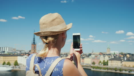 una mujer está fotografiando una hermosa vista de la ciudad de estocolmo en suecia vista trasera turismo en sc