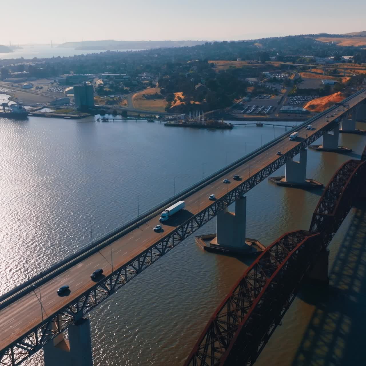 Beautiful sight of Martinez shore at the bay of California. Bridges with cars and trucks moving by. Sunny day aerial footage