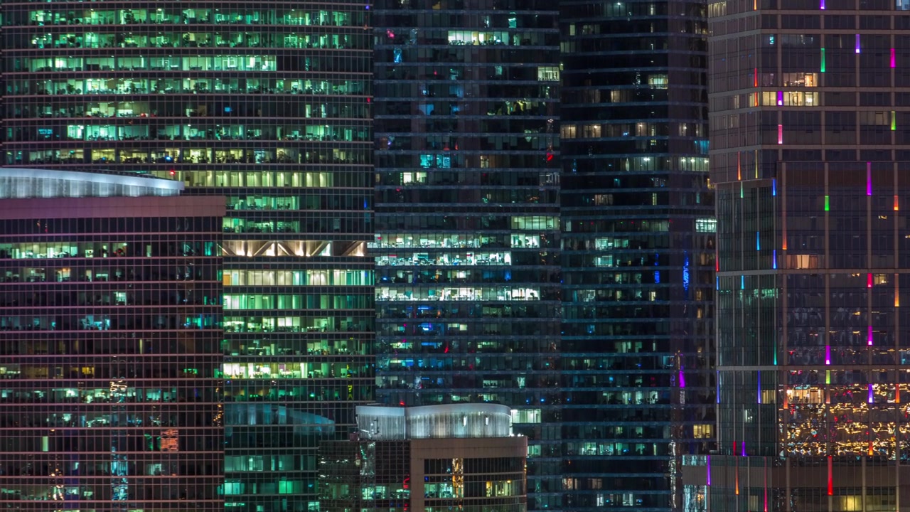 Modern office building with glowing windows at night timelapse. Moscow city. Close up view from rooftop. Zoom in