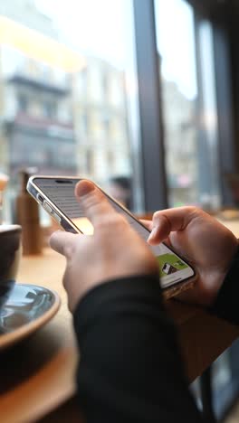 persona que usa un teléfono inteligente en un café