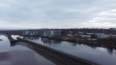 Early-morning-aerial-view-riverside-waterfront-contemporary-apartment-office-buildings-canal-regeneration-real-estate-low-push-in