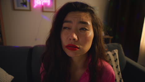 close up of confused woman sitting on sofa after drinking alcohol at house party suffering with hangover 1