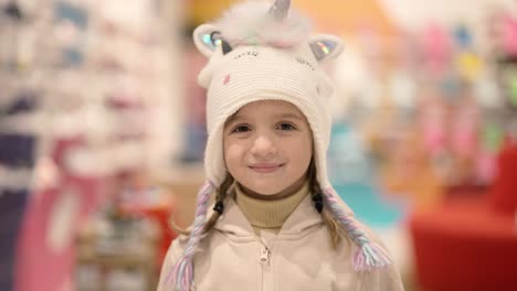 Mother-and-daughter-try-on-cute-cartoon-hat-in-the-shopping-mall