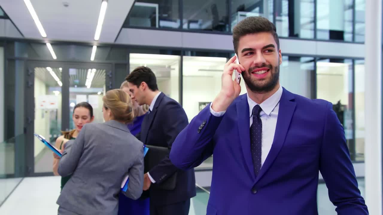 hombre de negocios hablando por teléfono móvil mientras los hombres de negocios discuten en segundo plano