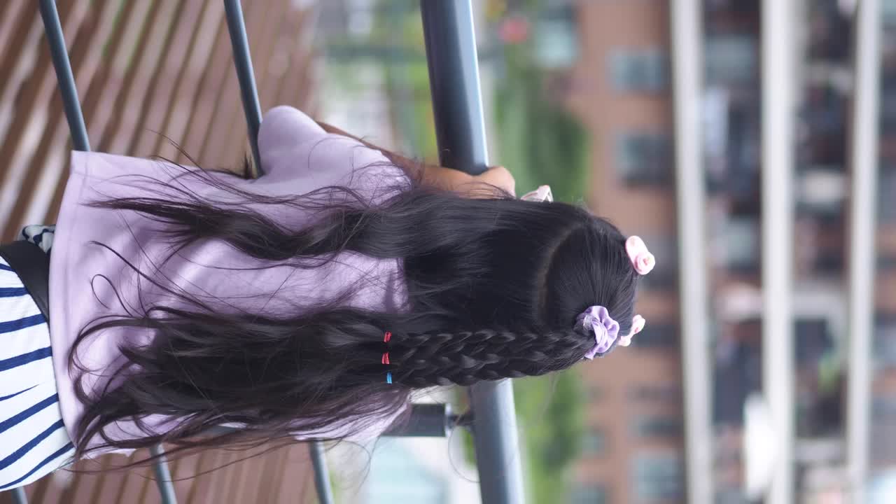 A girl with a braided hairstyle on a balcony