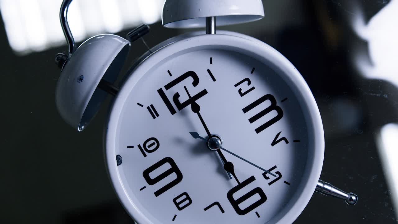 White alarm clock indicates 6 and starts to ring. Bottom view. Time concept.