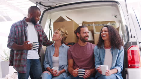 slow motion shot of friends helping couple to unload removal truck on moving day