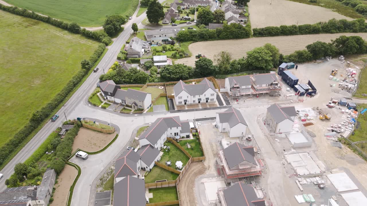 Aerial exterior view of new build development in the UK, showcasing houses under construction and surrounding area