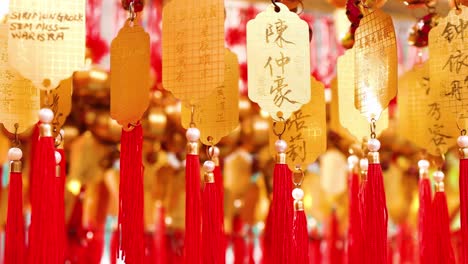 close-up of golden plaques with red tassels, showcasing intricate calligraphy and vibrant colors.