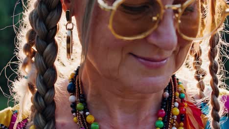 close-up of a smiling woman with braids and colorful accessories