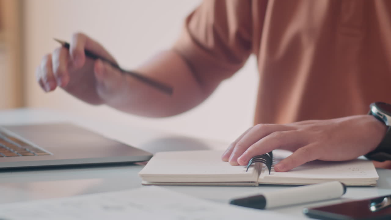 Hands of Entrepreneur Making Notes and Working on Laptop