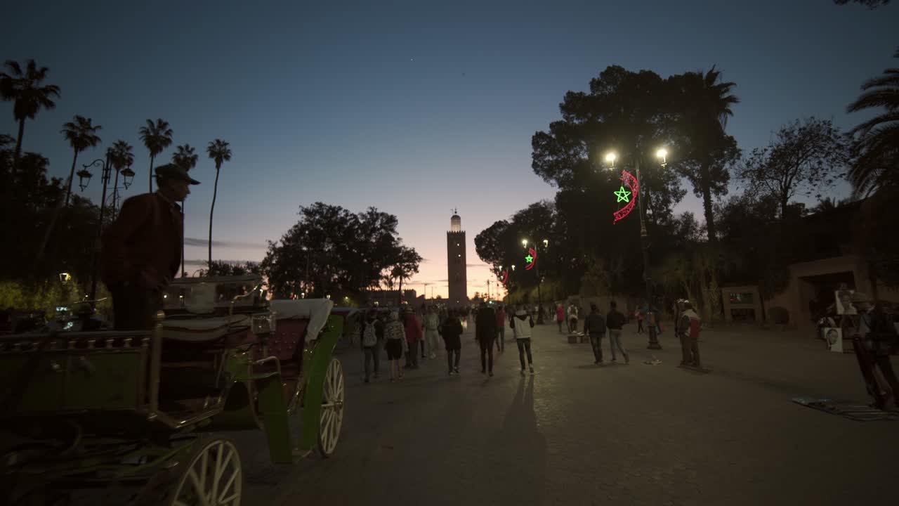 turistas y ciudadanos caminando por marrakech al anochecer