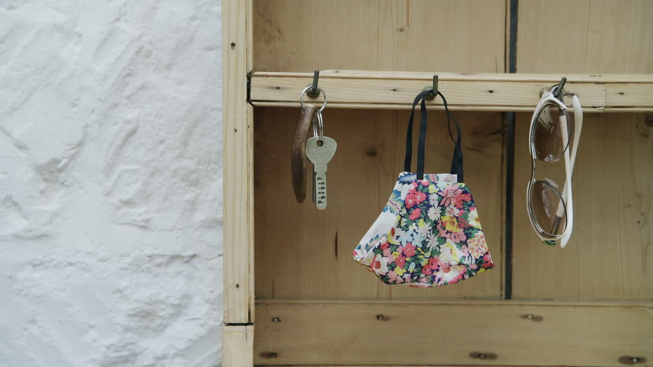 Person grabs face mask, keys and sunglasses before leaving home