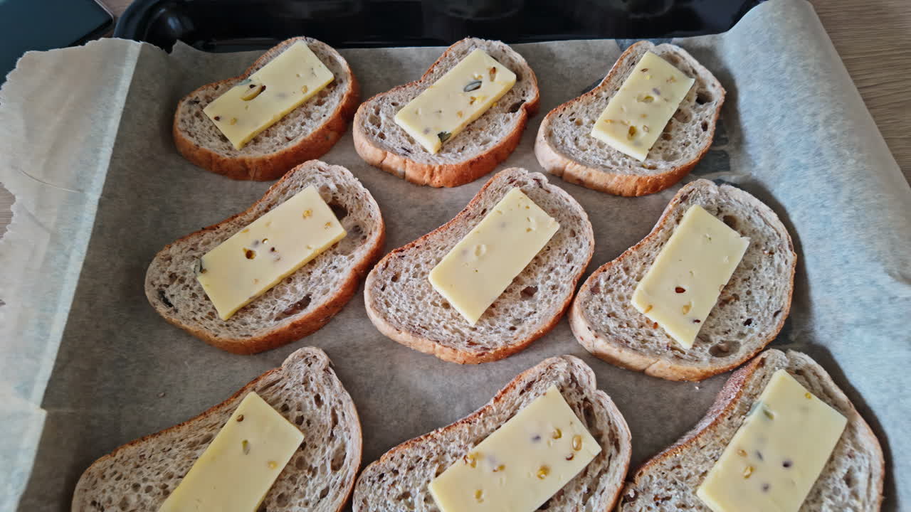 Slices of bread with cheese on a baking sheet