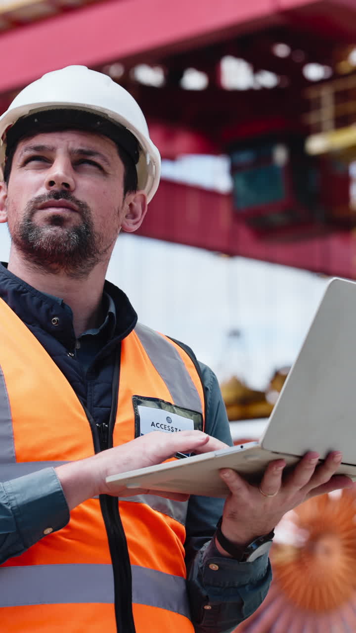 Focused Engineer in Hard Hat Working on Laptop at Industrial Site