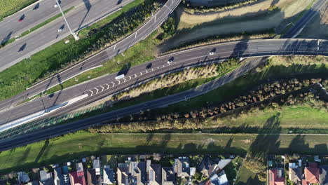 perspectiva aérea de seguimiento suave tomada desde arriba hacia abajo de los vehículos que ingresan a la vía principal del principal cruce de autopistas a continuación