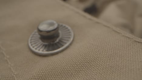 macro pull out of a metallic button on a coat