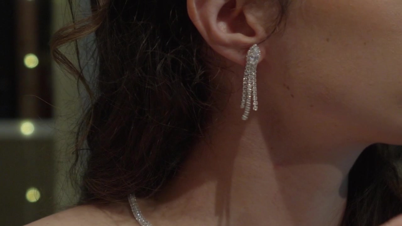 Primo piano di una sposa in Bretagna, Francia, che indossa eleganti orecchini scintillanti mentre si prepara per la cerimonia nuziale
