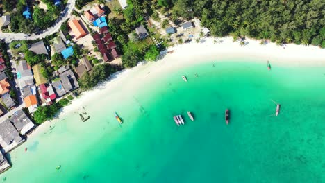 Schöner-Sonnentag-über-Der-Thailändischen-Küste-Mit-Türkisfarbenem-Meer,-Festgemachten-Booten-Und-Bunten-Hausdächern