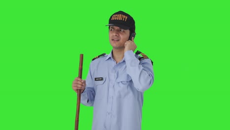 Confused-Indian-security-guard-talking-on-phone-Green-screen