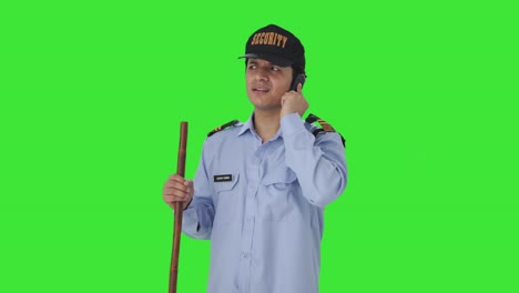 confused indian security guard talking on phone green screen
