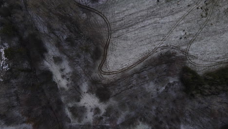 Flying-over-the-trees-and-overlooking-the-forest-during-a-light-beginning-snowfall