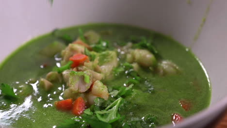 sprinkling chopped cilantro leaves on peruvian seafood soup