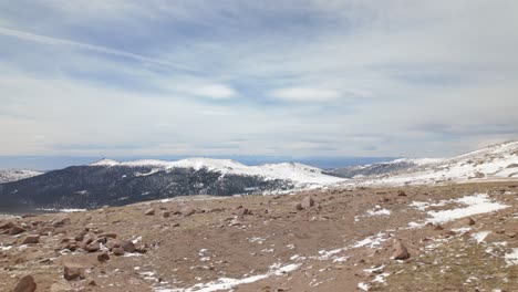 snow-covered mountains with rocky foreground at pikes peak in el paso county, colorado. wide shot