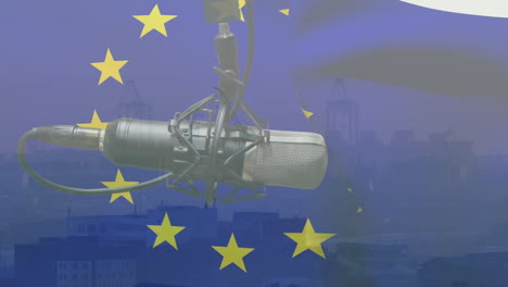 animation of waving eu flag over microphone against aerial view of cityscape